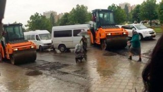 На Чеканах рабочие асфальтировали дорогу во время дождя